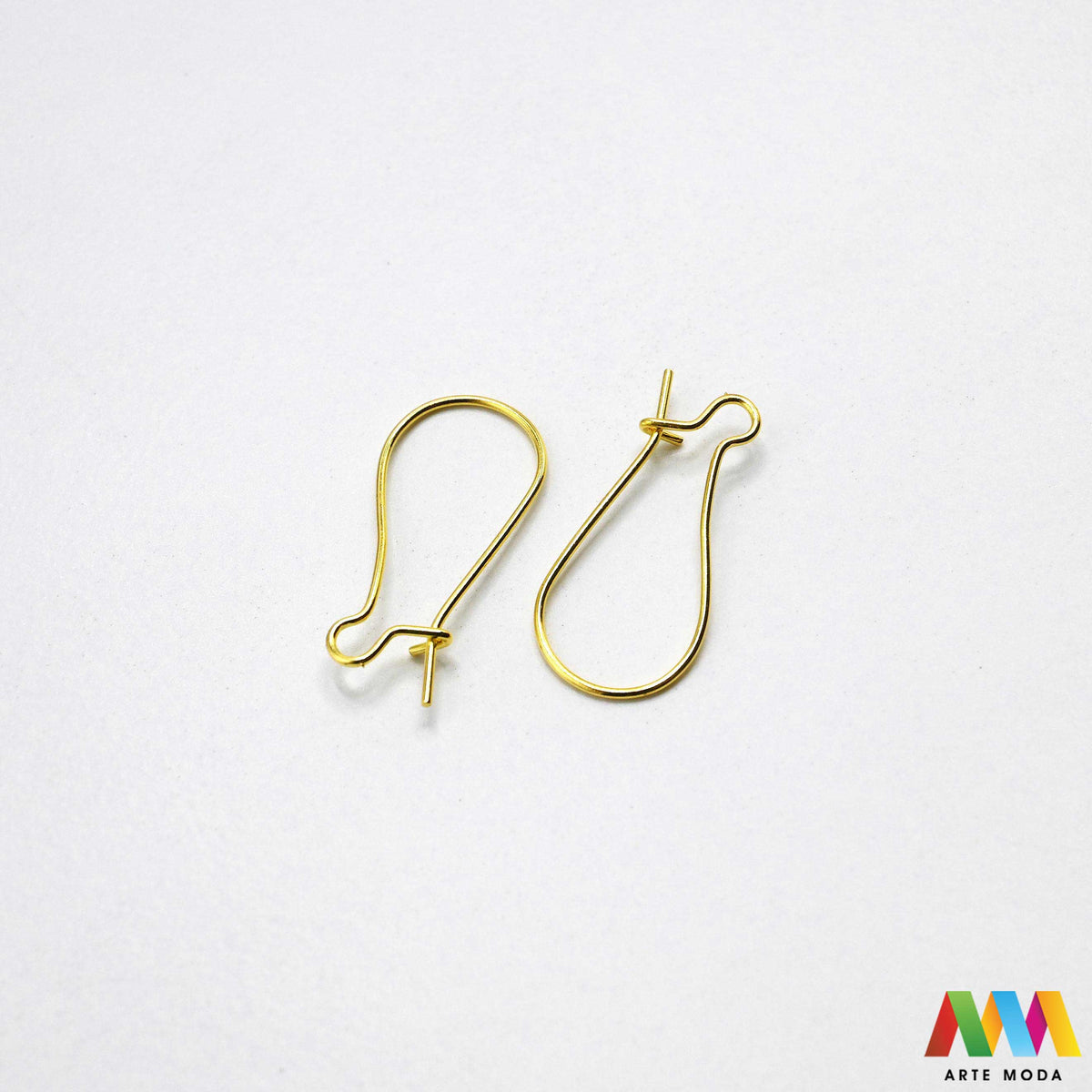 Klasične metalne udice za naušnice u srebrnoj zlatnoj bakrenoj brončanoj boji složene na radnoj plohi za izradu nakita Prikazane su zakrivljene riblje kukice fish hooks s dekorativnom kuglicom oprugom otvorenom prednjom omčicom za vješanje privjesaka kristala perli Kvalitetan i lagan repromaterijal za uši namijenjen za izradu visećih naušnica u kreativnim DIY radionicama za ručnu izradu modnog nakita s glatko obrađenim vrhovima koji osiguravaju ugodno i sigurno nošenje bez grebanja arte moda repromaterijali