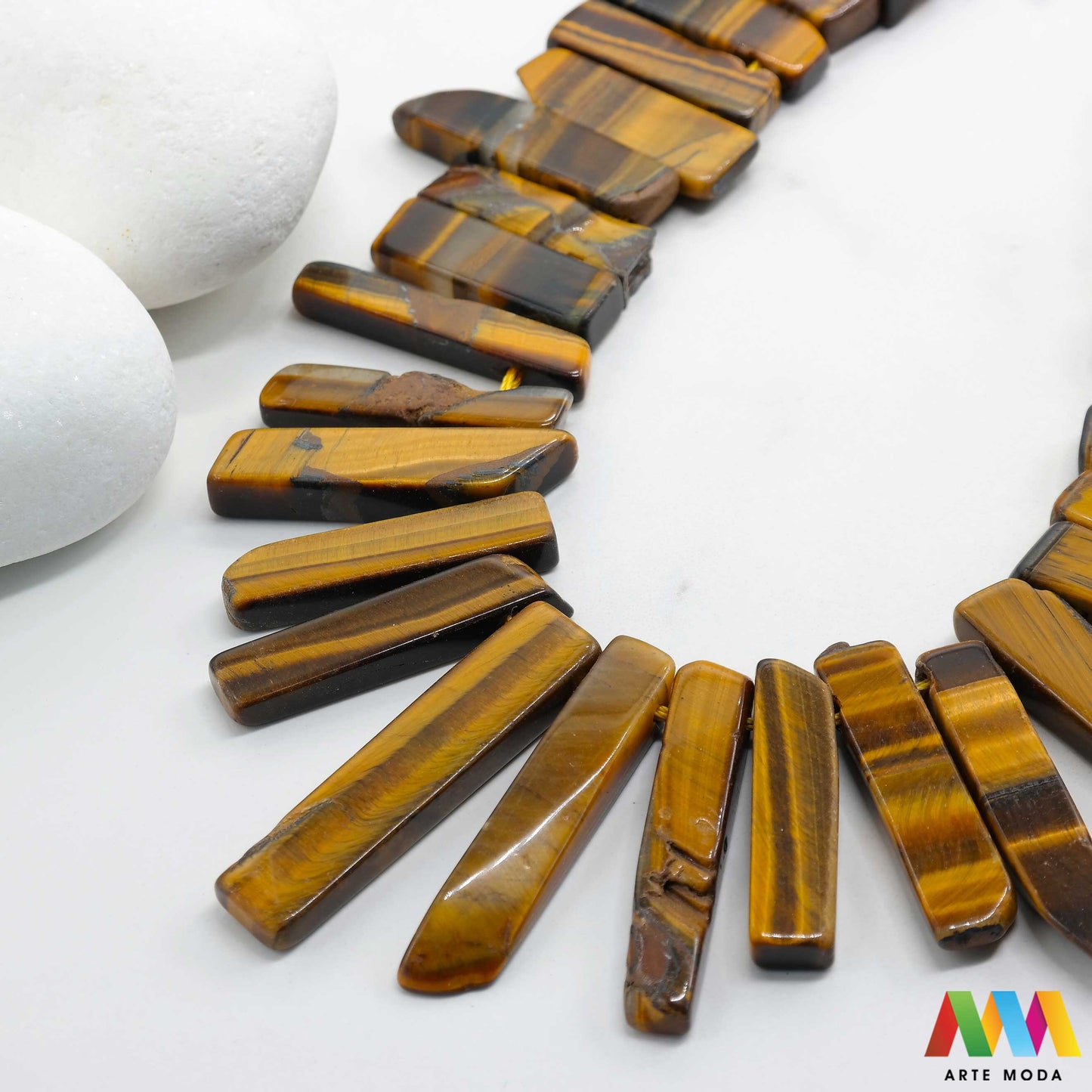 tigrovo oko dragi kamen dragulj poludrago kamenje repromaterijal poludragi ukrasni mineral kristal Tigrovo oko je kamen koji se opravdano nalazi na samom vrhu ljestvice omiljenih svjetskih kristala Prepoznatljiv je po zadivljujućim naizmjeničnim slojevima zlatne i smeđe boje Ljubitelje kristala posebno očaravaju upravo te tople nijanse kao i njegov svilenkast sjaj te glatka i vlaknasta struktura