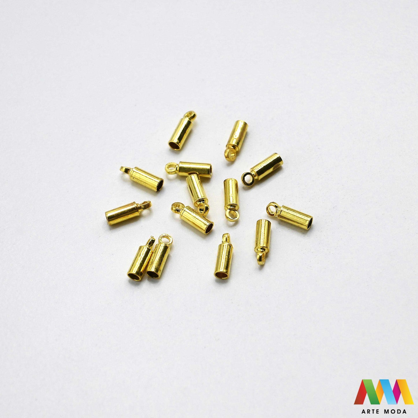 Raznolike metalne završne kapice za izradu nakita u srebrnoj zlatnoj brončanoj boji složene na radnoj površini Prikazane su okrugle cjevaste i zvonolike metalne kapice s omčicom namijenjene za uredno završavanje kožnih traka gumenih nizeva špaga i višestrukih nizova perli Kvalitetan repromaterijal i fiksatori za spajanje s kopčama pri izradi unikatnih ogrlica i narukvica u DIY radionicama za izradu ručno rađenog modnog nakita s preciznim otvorima za sigurno lijepljenje i stiskanje arte moda repromaterijali