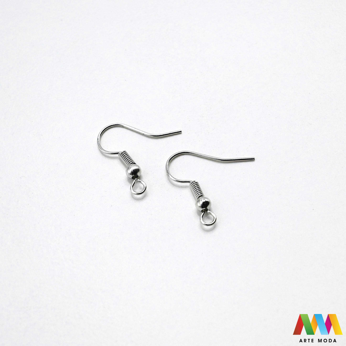 Klasične metalne udice za naušnice u srebrnoj zlatnoj bakrenoj brončanoj boji složene na radnoj plohi za izradu nakita Prikazane su zakrivljene riblje kukice fish hooks s dekorativnom kuglicom oprugom otvorenom prednjom omčicom za vješanje privjesaka kristala perli Kvalitetan i lagan repromaterijal za uši namijenjen za izradu visećih naušnica u kreativnim DIY radionicama za ručnu izradu modnog nakita s glatko obrađenim vrhovima koji osiguravaju ugodno i sigurno nošenje bez grebanja arte moda repromaterijali
