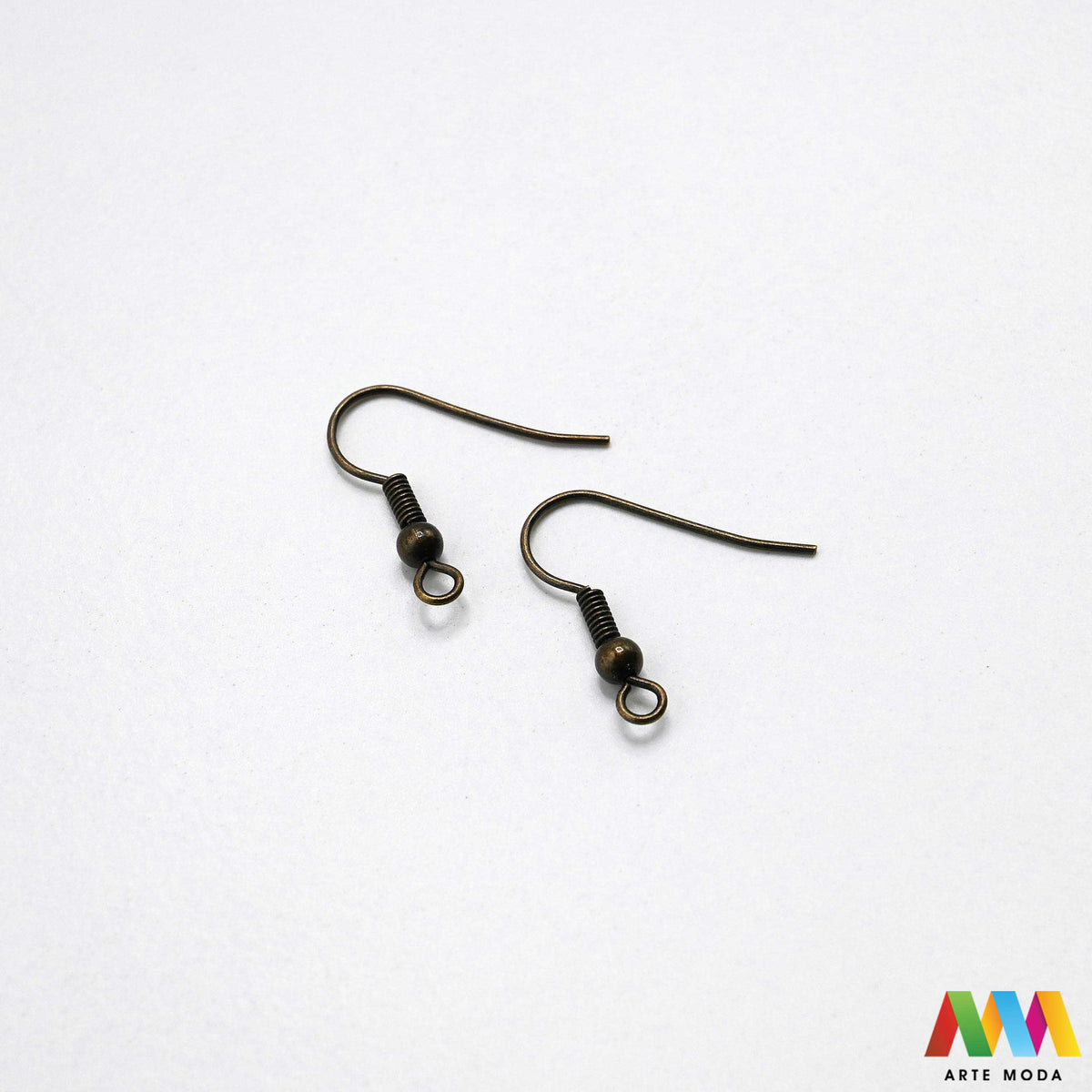 Klasične metalne udice za naušnice u srebrnoj zlatnoj bakrenoj brončanoj boji složene na radnoj plohi za izradu nakita Prikazane su zakrivljene riblje kukice fish hooks s dekorativnom kuglicom oprugom otvorenom prednjom omčicom za vješanje privjesaka kristala perli Kvalitetan i lagan repromaterijal za uši namijenjen za izradu visećih naušnica u kreativnim DIY radionicama za ručnu izradu modnog nakita s glatko obrađenim vrhovima koji osiguravaju ugodno i sigurno nošenje bez grebanja arte moda repromaterijali
