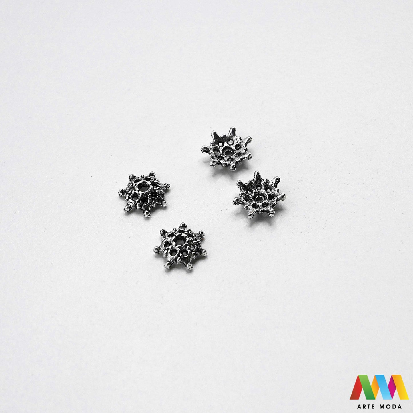 Luksuzne metalne filigranske ljevane kapice za perle u srebrnoj zlatnoj i brončanoj boji izložene Prikazane su čvrste i detaljno lijevane ornamentne kapice krunice i zvonoliki ukrasi koji obujmljuju okrugle staklene drvene i kamene perle pri izradi nakita Vrhunski metalni repromaterijal i masivniji dekorativni razdjelnici s preciznim rupama za nizanje namijenjeni za izradu unikatnih ogrlica narukvica i visećih naušnica u DIY radionicama za ručnu izradu modnog i vintage nakita arte moda repromaterijali